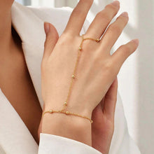 Load image into Gallery viewer, A delicate gold chain hand bracelet with matching ring and bracelet set on a model's hand, styled with a white blazer.