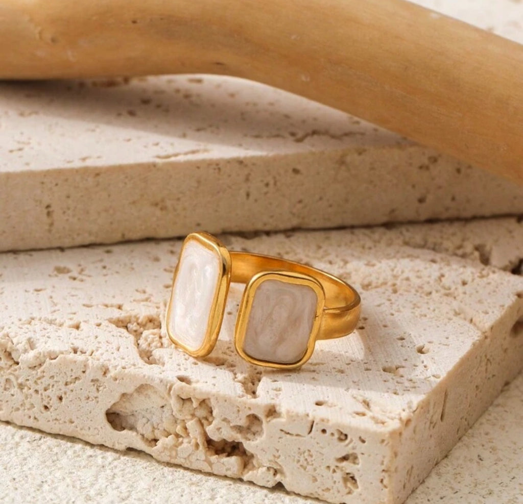 Flat lay of the Cloudstone Adjustable Ring showcasing its glossy pearl-like stone and open-ended adjustable band
