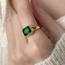 Load image into Gallery viewer, Gold ring with a green gemstone on a hand against a neutral background