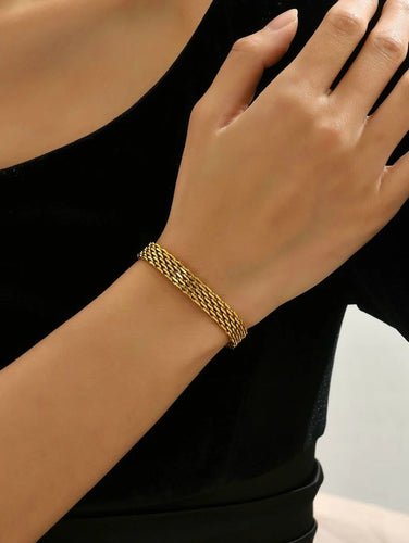 Gold bracelet on a person's wrist with a black sleeve