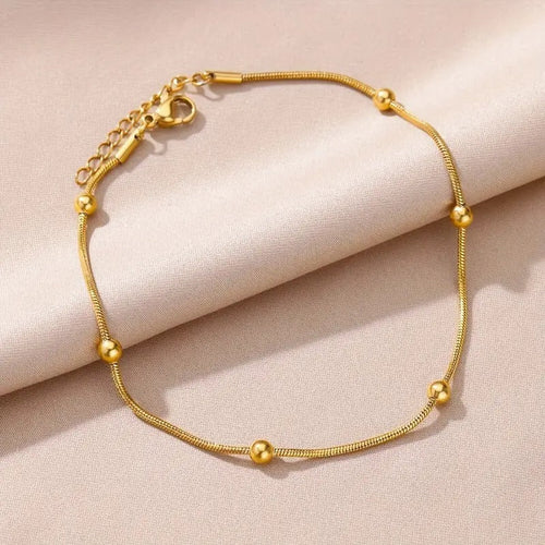 Gold bracelet on a beige fabric background