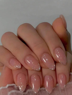 Close-up of a hand with pink glittery nails on a neutral background