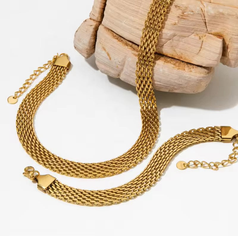 Gold chain bracelet on a textured surface