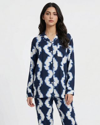 Woman wearing a navy and white tie-dye pajama set on a white background