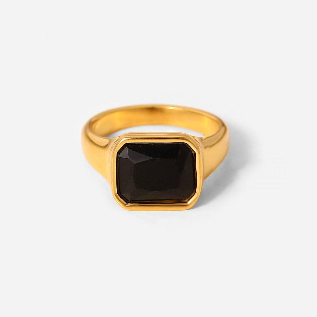 Gold ring with a black gemstone on a white background